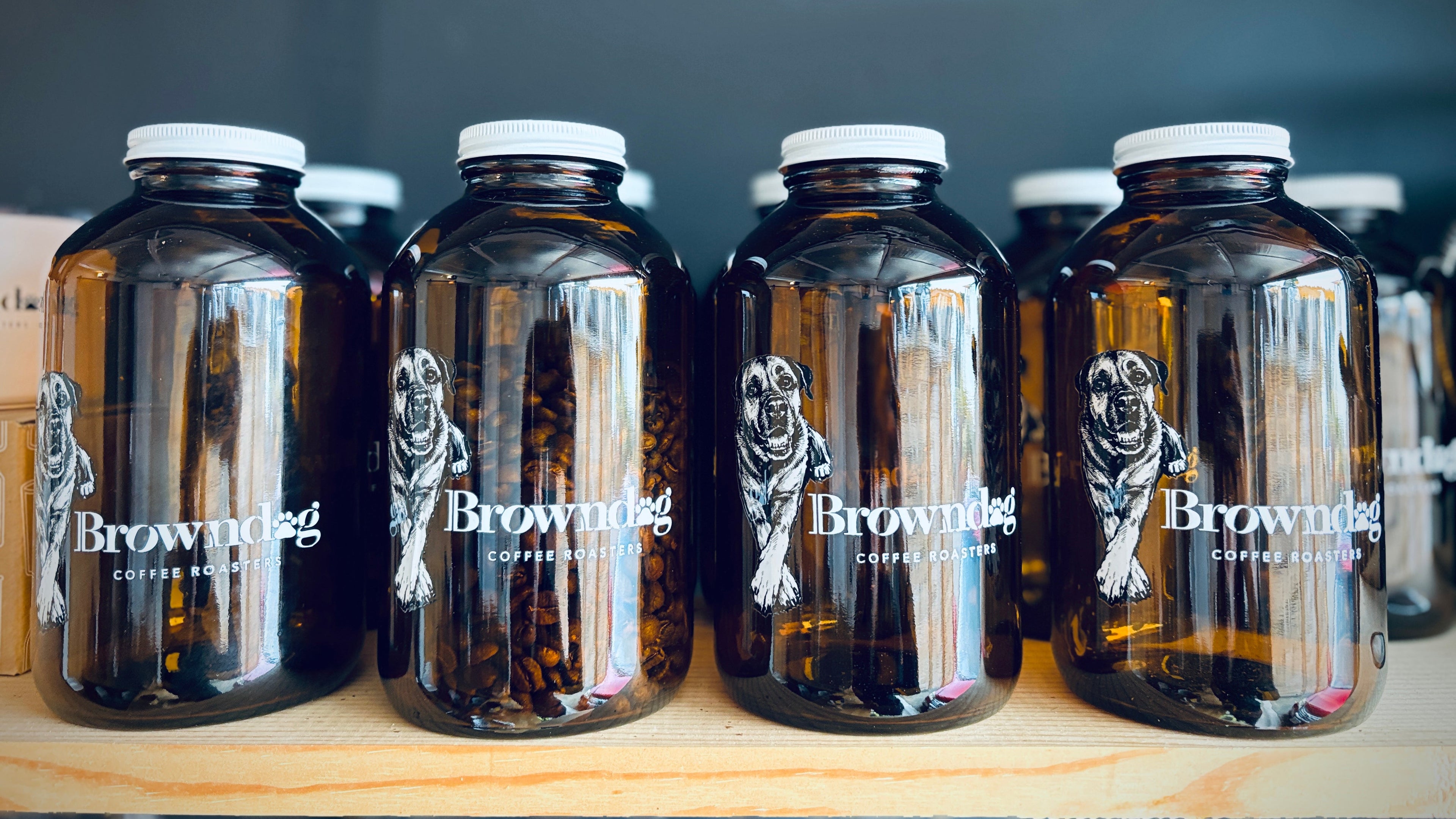Row of brown bottles with 'Brownndog' branding on a wooden surface.